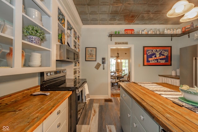 kitchen with wooden counters, crown molding, dark wood finished floors, an ornate ceiling, and stainless steel appliances