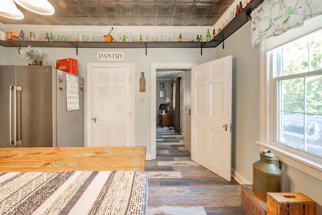 interior space featuring wood finished floors, baseboards, an ornate ceiling, and a healthy amount of sunlight