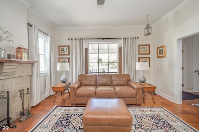living area featuring baseboards, ceiling fan, ornamental molding, and wood finished floors