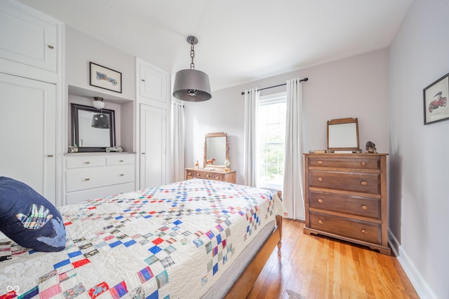 bedroom featuring baseboards and light wood-style flooring