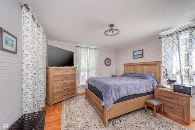 bedroom featuring light wood-type flooring and ornamental molding