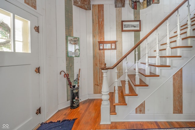 staircase with baseboards and wood finished floors