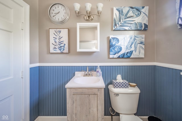 bathroom with vanity, wainscoting, and toilet