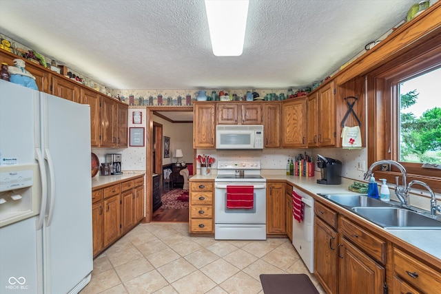 7020 N 375 E, Lebanon, IN 46052 - kitchen featuring brown cabinetry, a sink, white appliances, and light countertops