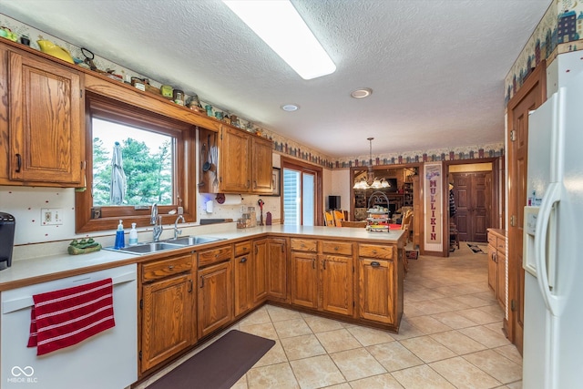 7020 N 375 E, Lebanon, IN 46052 - kitchen featuring a notable chandelier, a sink, white appliances, light countertops, and a peninsula