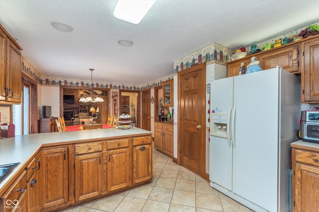 7020 N 375 E, Lebanon, IN 46052 - kitchen featuring brown cabinets, light countertops, an inviting chandelier, white fridge with ice dispenser, and light tile patterned flooring