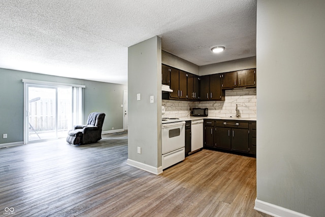 6814 Summer Time Dr, Indianapolis, IN 46226 - kitchen with dark brown cabinetry, tasteful backsplash, a sink, light wood-style floors, and white appliances
