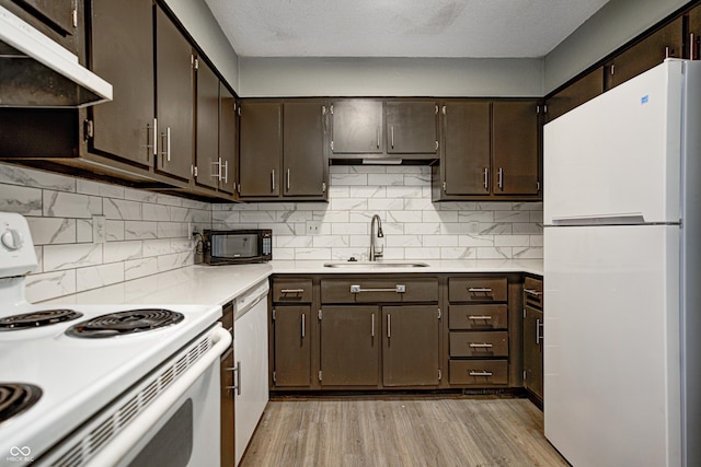 6814 Summer Time Dr, Indianapolis, IN 46226 - kitchen with white appliances, light countertops, under cabinet range hood, a sink, and light wood finished floors