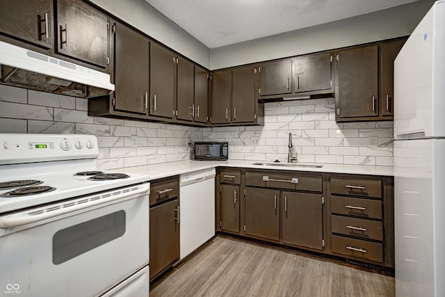 6814 Summer Time Dr, Indianapolis, IN 46226 - kitchen featuring a sink, light countertops, under cabinet range hood, white appliances, and light wood-style flooring
