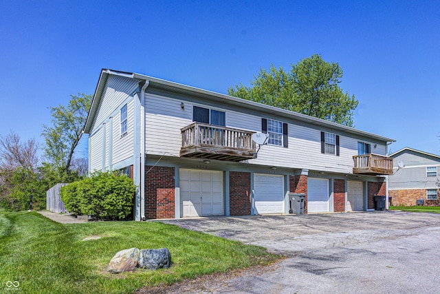 6814 Summer Time Dr, Indianapolis, IN 46226 - view of front facade featuring an attached garage, aphalt driveway, a balcony, and brick siding