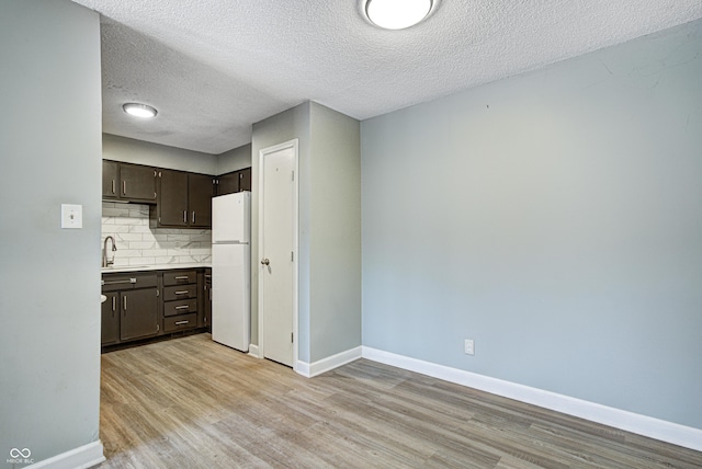 6814 Summer Time Dr, Indianapolis, IN 46226 - kitchen with a sink, freestanding refrigerator, light wood finished floors, and dark brown cabinets