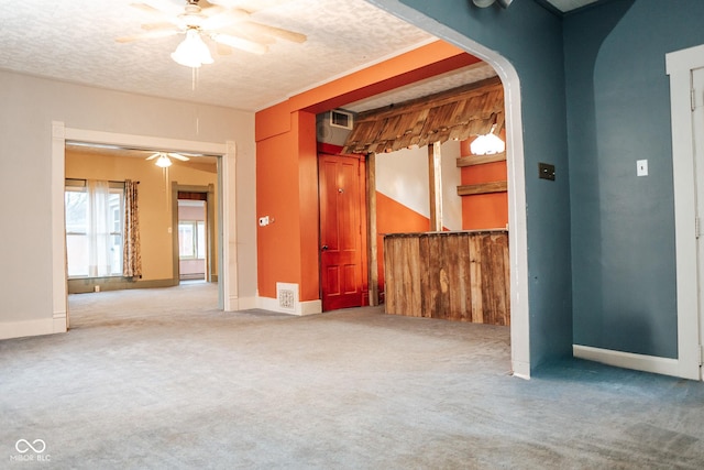 307 N Main St, Carthage, IN 46115 - carpeted empty room with a ceiling fan, arched walkways, and a textured ceiling