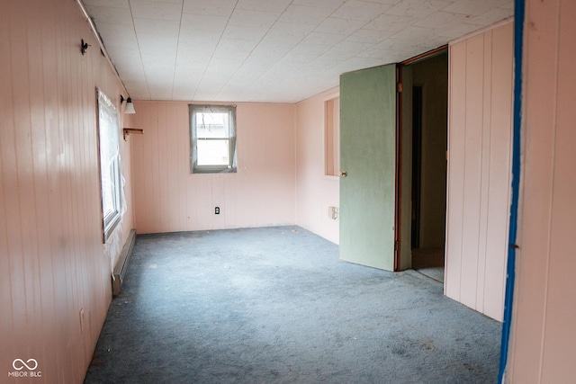 307 N Main St, Carthage, IN 46115 - spare room with carpet, wood walls, and a baseboard radiator