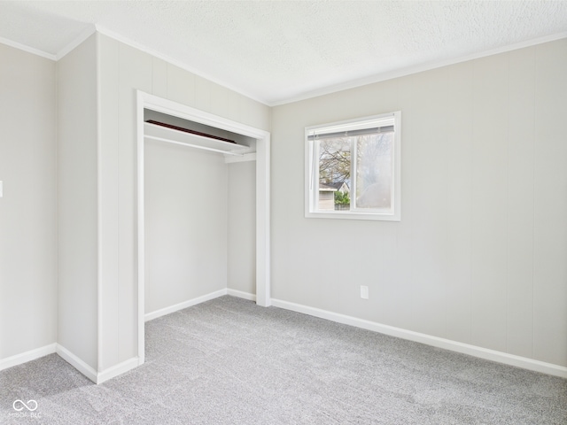 979 Monroe St, Indianapolis, IN 46229 - unfurnished bedroom with a textured ceiling, crown molding, baseboards, a closet, and carpet flooring