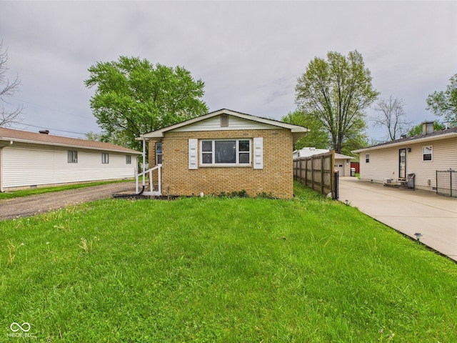 979 Monroe St, Indianapolis, IN 46229 - view of front of property with brick siding, fence, and a front yard
