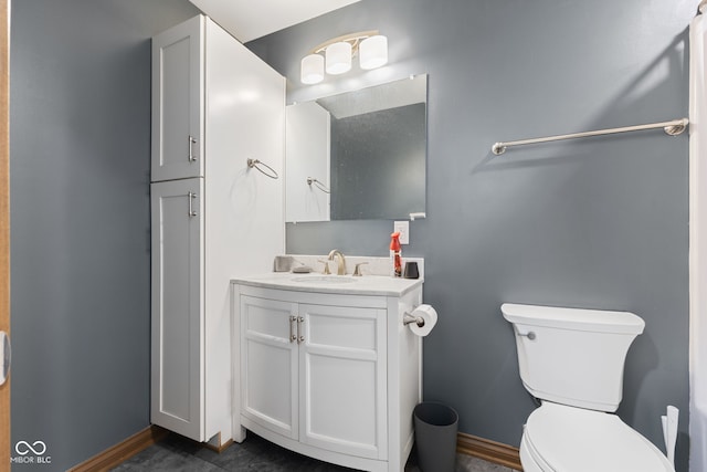 bathroom featuring vanity, toilet, and baseboards
