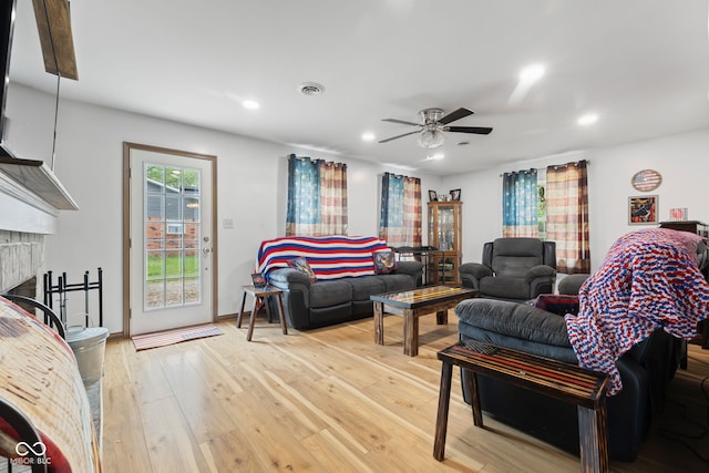 living room with light wood finished floors, a ceiling fan, a fireplace, visible vents, and recessed lighting