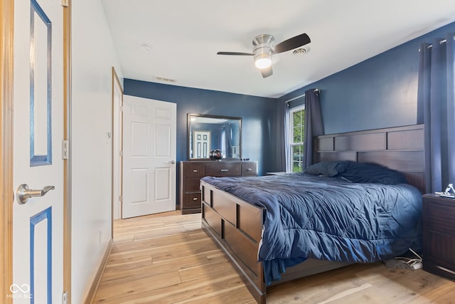 bedroom featuring visible vents, light wood-style flooring, baseboards, and ceiling fan