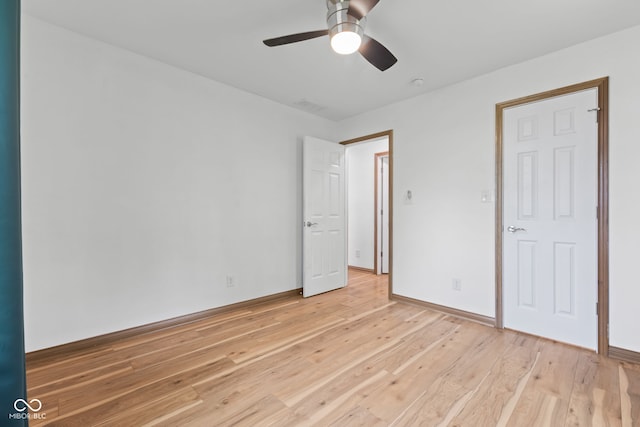 unfurnished bedroom featuring baseboards, light wood-type flooring, a ceiling fan, and visible vents
