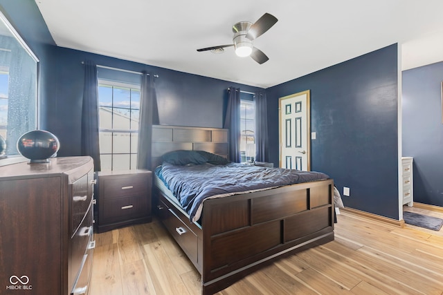 bedroom with a ceiling fan, multiple windows, and light wood-style floors