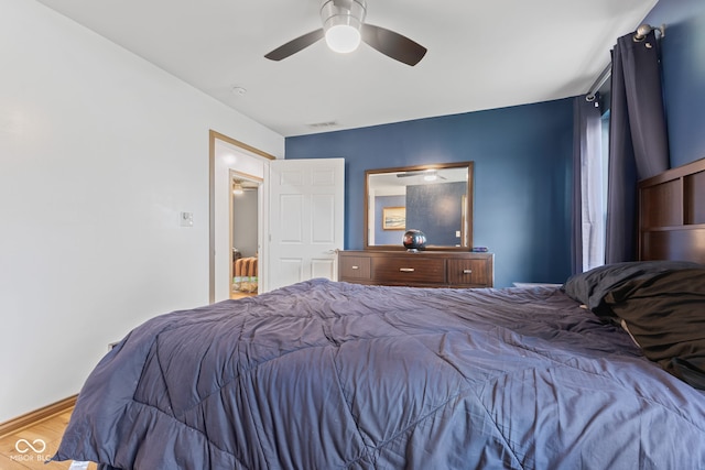 bedroom featuring ceiling fan, visible vents, and wood finished floors