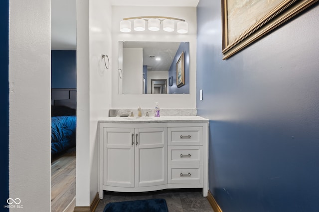 ensuite bathroom featuring baseboards, ensuite bathroom, and vanity