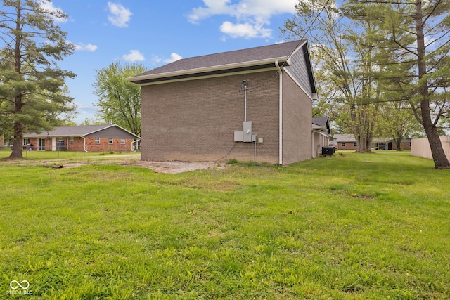 view of side of home featuring brick siding and a lawn