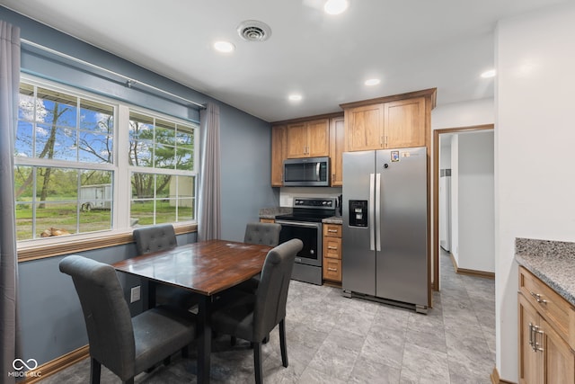 kitchen featuring recessed lighting, light stone counters, visible vents, and appliances with stainless steel finishes