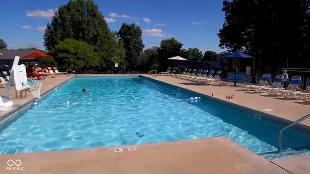 pool featuring fence and a patio area