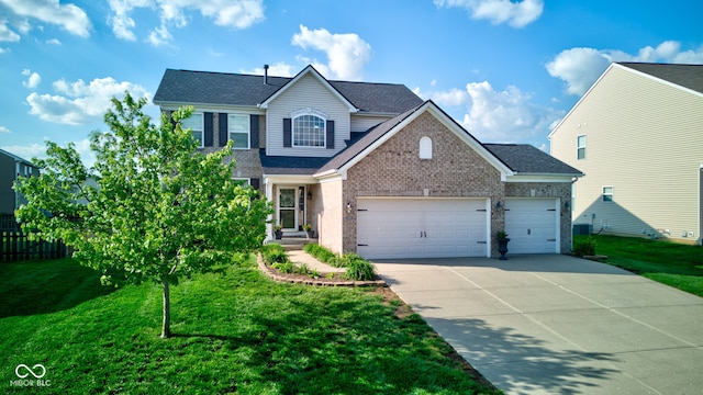 traditional-style house featuring a garage, concrete driveway, a front yard, and a shingled roof