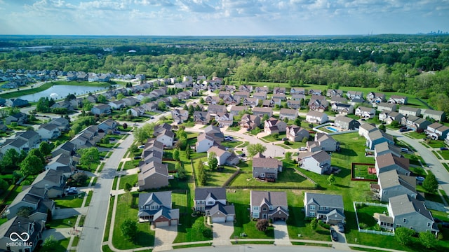aerial view of property and surrounding area with nearby suburban area and a large body of water