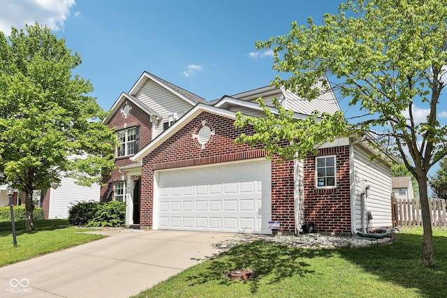 traditional home with driveway, a front yard, a garage, brick siding, and fence