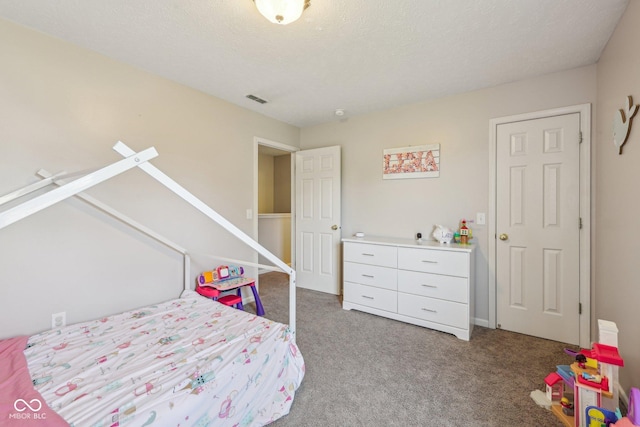 bedroom featuring visible vents, a textured ceiling, and carpet