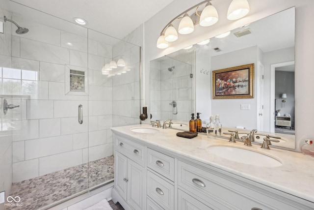 full bath featuring a sink, a stall shower, double vanity, and visible vents
