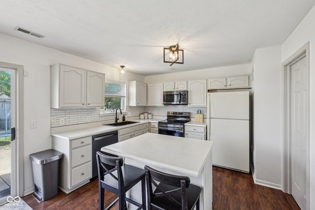 kitchen with appliances with stainless steel finishes, decorative backsplash, a sink, and visible vents