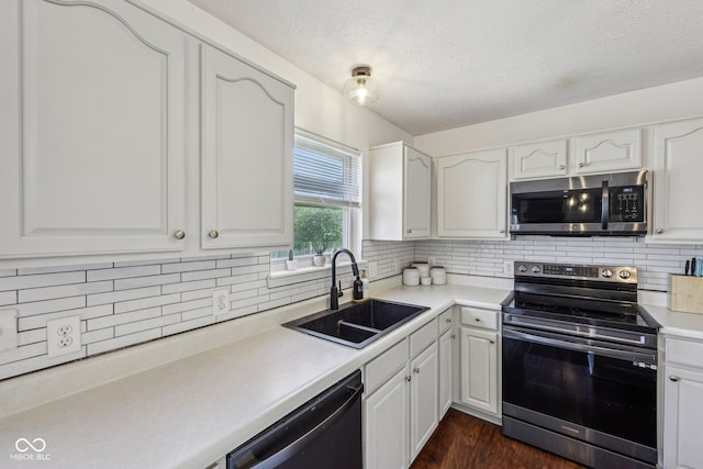 kitchen featuring white cabinets, a textured ceiling, appliances with stainless steel finishes, and a sink