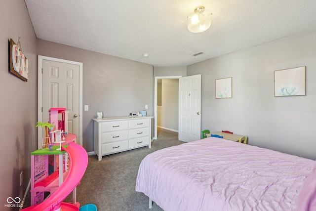 bedroom with dark carpet, a textured ceiling, and visible vents
