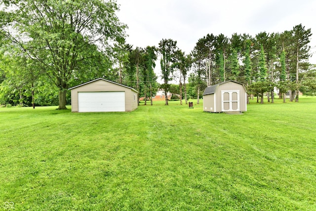 12087 N Gasburg Rd, Mooresville, IN 46158 - view of grassy yard featuring a garage, view of wooded area, and a storage shed