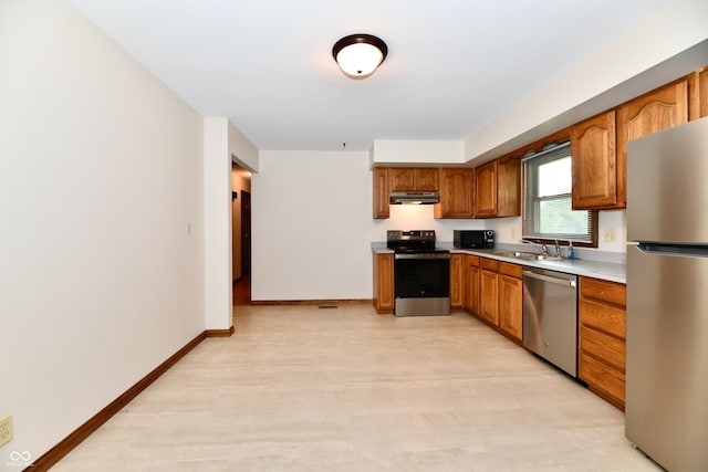 12087 N Gasburg Rd, Mooresville, IN 46158 - kitchen featuring stainless steel appliances, under cabinet range hood, brown cabinetry, and light countertops