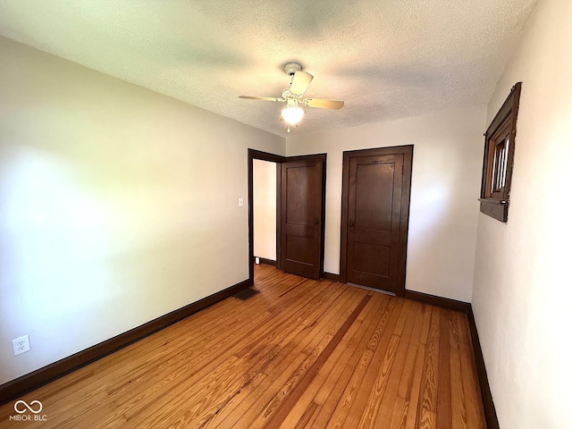 324 E Southern Ave, Indianapolis, IN 46225 - unfurnished bedroom with baseboards, a textured ceiling, light wood-type flooring, and a ceiling fan