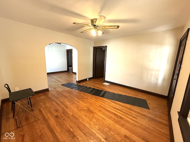 324 E Southern Ave, Indianapolis, IN 46225 - empty room featuring arched walkways, a ceiling fan, baseboards, and wood finished floors