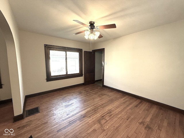 324 E Southern Ave, Indianapolis, IN 46225 - empty room with arched walkways, a ceiling fan, baseboards, and dark wood-style flooring