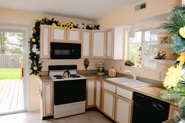 10691 Morristown Ct, Carmel, IN 46032 - kitchen featuring black appliances, a sink, light countertops, and cream cabinetry