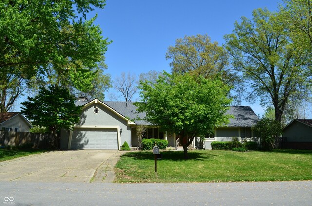 931 Beech Dr, Greenwood, IN 46142 - ranch-style home with a garage, fence, a front lawn, concrete driveway, and stucco siding