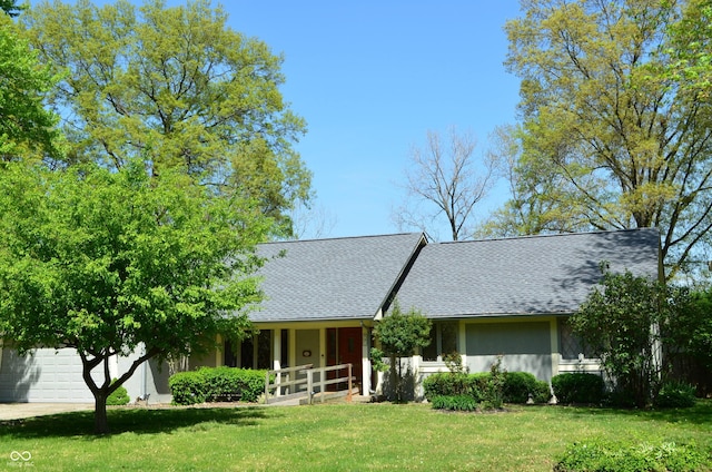 931 Beech Dr, Greenwood, IN 46142 - view of front facade with an attached garage, roof with shingles, stucco siding, and a front yard