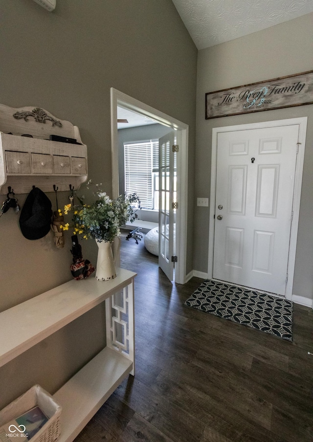 entryway featuring baseboards, vaulted ceiling, and dark wood-style floors