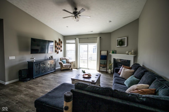 living area featuring baseboards, a ceiling fan, lofted ceiling, and wood finished floors