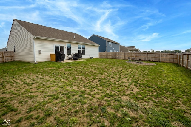rear view of property featuring a fenced backyard, a yard, a patio area, and an outdoor fire pit