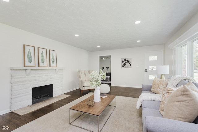 living room with recessed lighting, baseboards, wood finished floors, and a fireplace