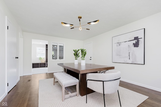 dining area featuring baseboards, an inviting chandelier, wood finished floors, and visible vents